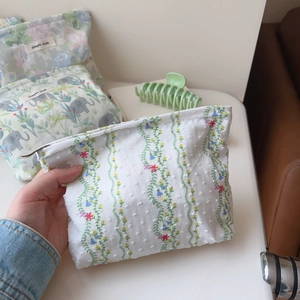 Close-up of floral print cotton makeup bag with zip closure and polka dot texture