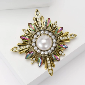 Detailed macro of vintage baroque sunburst brooch with pearls and colorful gemstones