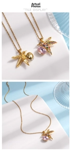 Macro shot of hummingbird pendant with colorful crystals and pink stone on gold chain