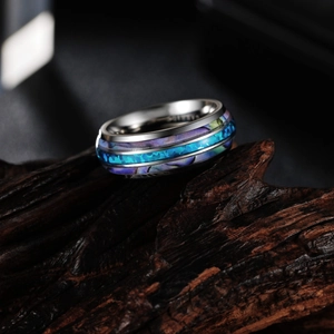 Bague en acier titane poli avec incrustation d'opale bleue sur socle en bois
