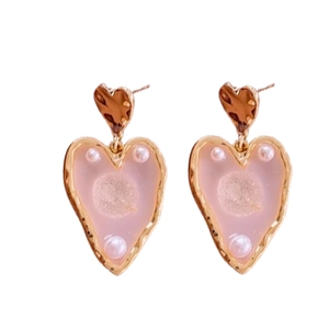Pink heart drop earrings with gold plating and white pearl accents on white background