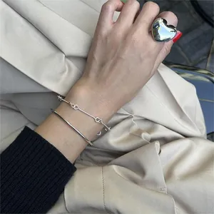 Close-up of a minimalist silver S925 open bangle with modern geometric thin line design