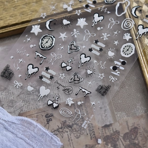 Macro detail of metallic silver nail stickers featuring dark style hearts and stars