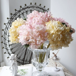 Close-up of vintage hydrangea silk flowers in a textured glass vase for home decor