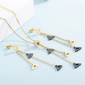 Detailed view of golden triangle fringe necklace with crystal-embedded rings and matching earrings