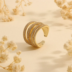 Close-up of golden multi-layer ring with pavé-set zircons and dried flowers décor