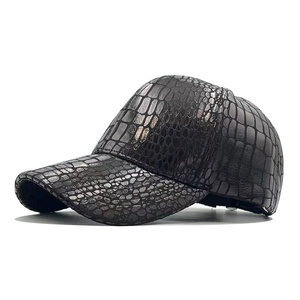 Detailed macro shot of dark brown crocodile-textured PU leather on a baseball cap