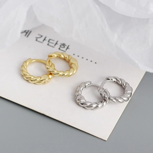 Detailed view of gold and silver twisted hoop earrings with elegant spiral metal texture