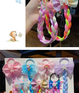Close-up of colorful braided hair extensions with bow clips and cute cartoon decorations