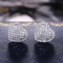Macro shot of silver heart-shaped stud earrings with sparkling white cubic zirconia