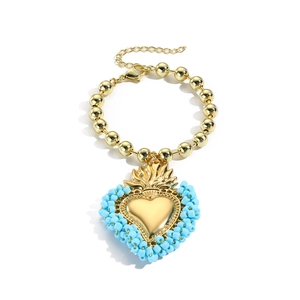 Boho-Armband mit goldenen Perlen und einem hellblau-goldenen Herzanhänger mit Krondetails