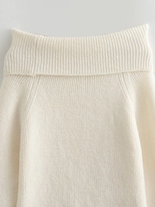 Détail de l'encolure bateau blanc crème et de la texture délicate du tissu en maille fine