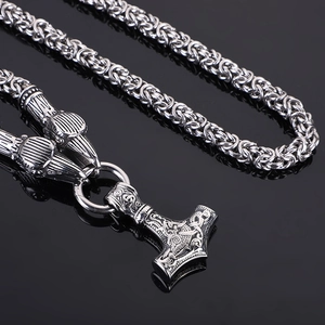 Macro detail of silver Thor's hammer Mjolnir pendant on braided metal chain