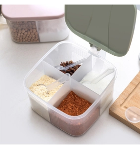 Detail view of a 4-compartment plastic spice box with green lid and individual serving spoons