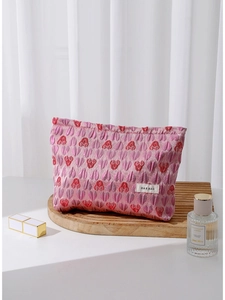 Pink heart jacquard makeup bag with H&R logo on a stylish wooden wave display base