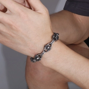 Dettaglio di un bracciale punk teschio vintage con finitura argento antico e catena link