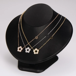 Sparkling floral diamond necklace set in rose gold, silver, and gold on a black display stand