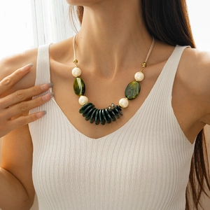 Close-up of double-layered acrylic oval pendant necklace on model in casual white tank top