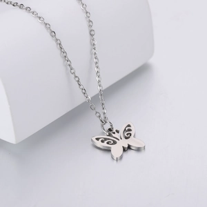 Macro shot of silver hollow butterfly pendant on a delicate stainless steel chain necklace
