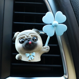 Detailed view of pug car air vent clip holding a blue clover windmill on a dashboard