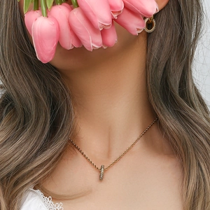 Model wearing gold 18K plated twist chain necklace and rhinestone hoop earrings set