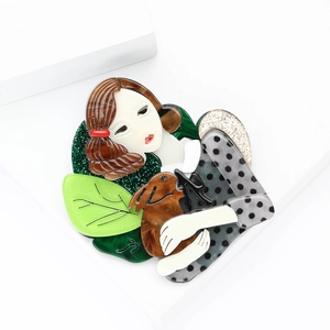 Acrylic brooch featuring a girl holding a puppy with green glitter leaves decoration