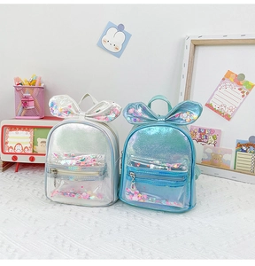 Detail of silver and teal kids backpacks with sequin bow and holographic finish