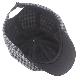 Detail view of the black and white plaid newsboy cap with adjustable metal back strap