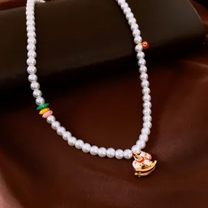 Collier de perles élégant avec perles colorées et pendentif cheval à bascule doré