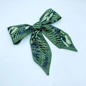 Detailed flat lay of green bohemian wrist strap with fern patterns and stitched edges