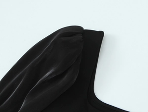 Détail des manches bouffantes élégantes et texture froncée d'un haut noir extensible