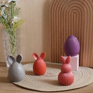 Detailed view of textured Easter bunny and egg candles in varied pastel colors and stripes