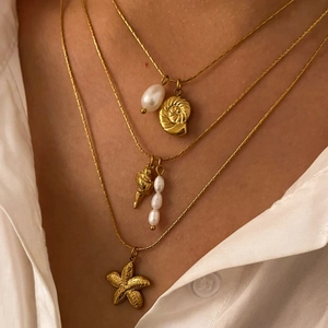 Minimalist layered necklace with freshwater pearls, starfish and conch pendants