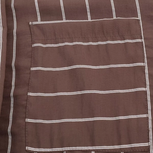 Macro detail of brown striped fabric with high-quality stitching on the pocket seam