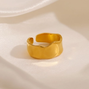 Minimalist gold plated stainless steel irregular wavy ring on white silk background