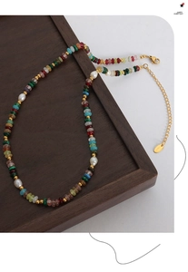 Detail of colorful gemstone necklace with freshwater pearls and gold lobster clasp closure