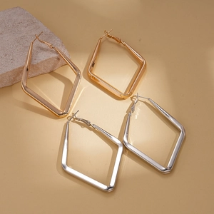 Minimalist geometric rhombic hoop earrings in gold and silver finish on a stone base