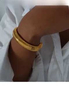 Detailed view of a thick gold Tubogas chain bracelet with polished metallic texture