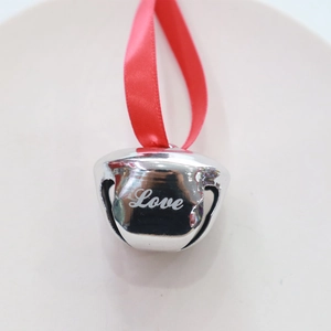 Close-up of 38mm silver metal bell with Love engraving and a red hanging ribbon