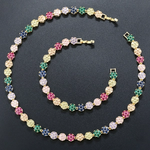 Elegant gold flower jewelry set with colorful crystals featuring necklace and bracelet