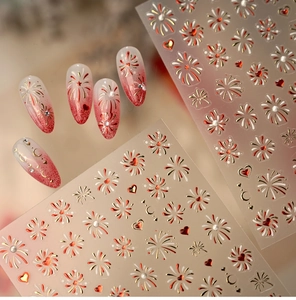 Detail of red and gold firework heart nail stickers with finished gradient nail tips