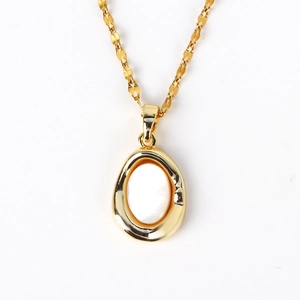 Macro shot of gold oval pendant featuring natural mother of pearl inlay and delicate chain
