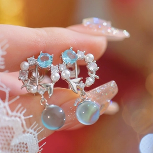 Elegant mermaid bubble earrings with blue zircon and pearls shown on a model