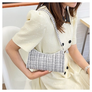 Gros plan d'un sac à bandoulière en tweed à carreaux noir et blanc à texture tissée