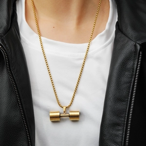 Close-up of a men's golden dumbbell pendant necklace worn with a stylish black leather jacket