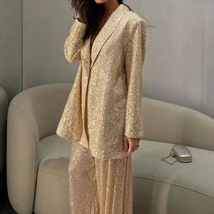 Détail de l'ensemble blazer et pantalon à paillettes dorées au fini étincelant