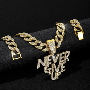 Close-up of golden Cuban link chain with rhinestone NEVER GIVE UP pendant on black background