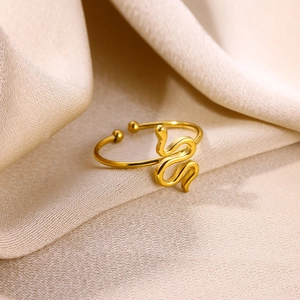 Vue macro d'une bague serpent plaquée or avec finition polie sur fond de soie champagne