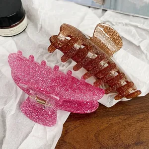 Glitter acrylic hair claws in vibrant pink and amber brown with strong gold metal spring