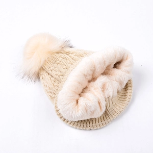 Detail of warm fleece lining and cable knit texture on women's winter beanie hat